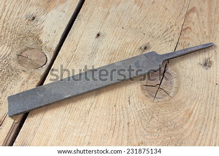 Old rusty rasp on wooden background