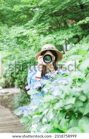 A woman taking a picture of a hydrangea