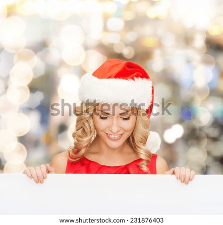 christmas, x-mas, people, advertisement and sale concept - happy woman in santa helper hat with blank white board over lights background