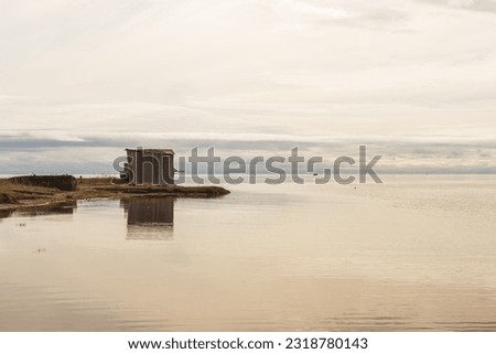 The White Sea coast near the village. Background on the seashore. Reflection of the house in the water