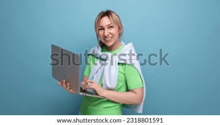 blond confident business lady in a casual look with a laptop in her hands on a blue background