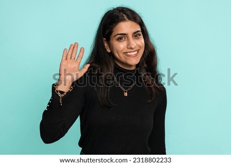 Come here, join us. Welcome. Hindu arabian woman showing inviting gesture with hands, ask to join, beckoning to coming, gesturing hello, goodbye. Pretty indian girl isolated on blue studio background Royalty-Free Stock Photo #2318802233