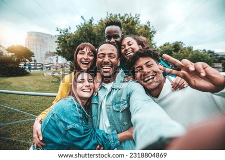 Multicultural friends taking selfie picture outside - Happy young people having fun walking on city street - Friendship concept with teenagers laughing at camera  