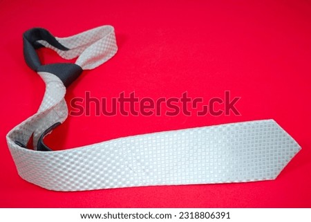 beautiful plain pattern polyester fabric necktie folded isolated over red background close up view single object nobody copy space for texting and commercial usage 