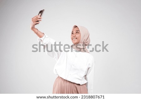 Asian muslimah take a selfie with her phone