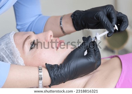 close-up illustrates a professional in sterile gloves performing a chin enhancement with hyaluronic acid. efficacy behind hyaluronic acid injections.