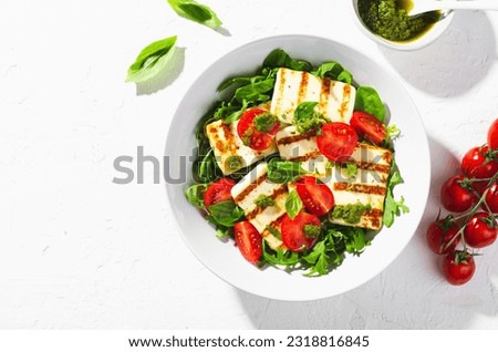Grilled Halloumi Cheese with Cheery Tomatoes and Pesto with Arugula, Spinach, and Basil, Ketogenic Paleo Diet Lunch, Healthy Easting Royalty-Free Stock Photo #2318816845