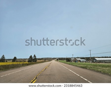 An open highway through a rural area on a clear spring day.