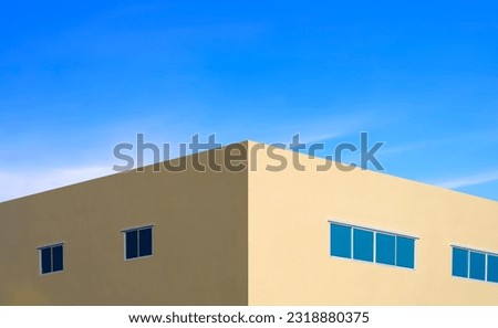 Symmetric and perspective view of yellow modern building with glass windows against blue sky background in minimal style
