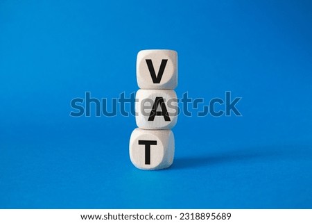 VAT - Value Added Tax symbol. Wooden cubes with word VAT. Beautiful blue background. Business and Value Added Tax concept. Copy space.