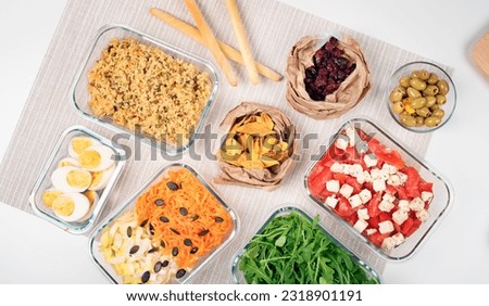 Batch cooking. Lunch box. Preparing meals for the week. Salad buffet. Balanced meal. Healthy food. Zero waste. Trendy meal. Carrots, dried mango, arugula, endive, olives, cheese, tomato,  cranberries. Royalty-Free Stock Photo #2318901191