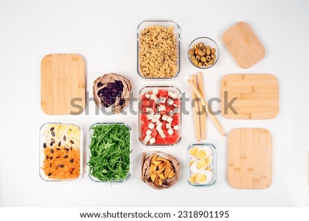 Batch cooking. Lunch box. Preparing meals for the week. Salad buffet. Balanced meal. Healthy food. Zero waste. Trendy meal. Carrots, dried mango, arugula, endive, olives, cheese, tomato,  cranberries. Royalty-Free Stock Photo #2318901195