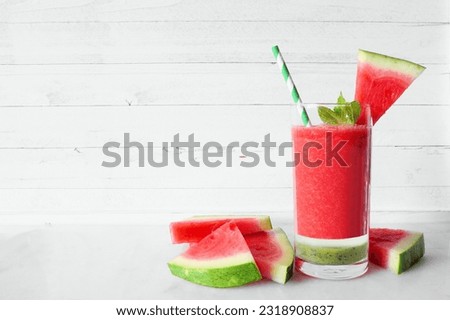 Refreshing layered watermelon drink. Side view against a white wood background. Summer food.