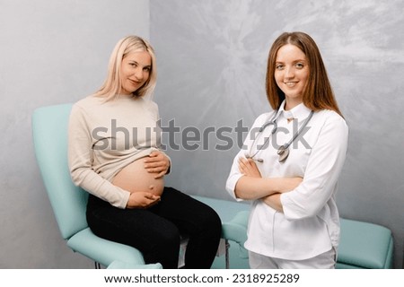 Gynecologist preparing for an examination procedure for a pregnant woman sitting on a gynecological chair in the office and smiling.