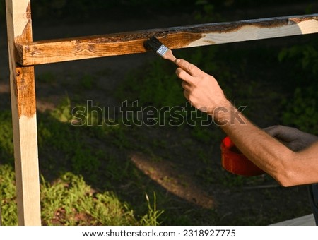 Application of paint and varnish coating on wood. outdoors Royalty-Free Stock Photo #2318927775