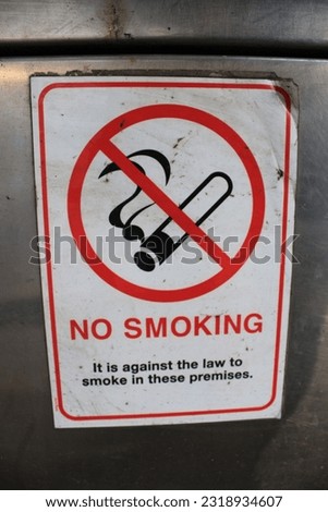 Grungy no smoking sign taken inside a public phone booth