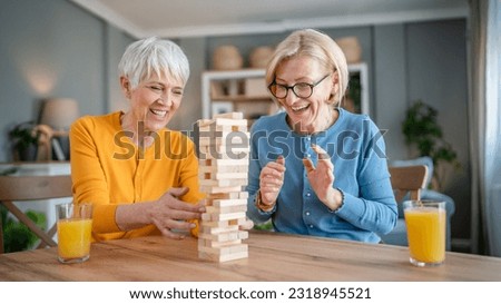 two senior women female woman friends or family sisters play leisure board game at home have fun pensioner grandmother spend time together with their mature daughter Royalty-Free Stock Photo #2318945521