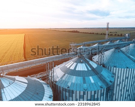 Modern metal silos on agro-processing and manufacturing plant. Aerial view of Granary elevator processing drying cleaning and storage of agricultural products, flour, cereals and grain. Nobody. Royalty-Free Stock Photo #2318962845