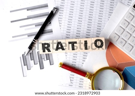RATIO text on a wooden block on graph background with pen and magnifier Royalty-Free Stock Photo #2318972903