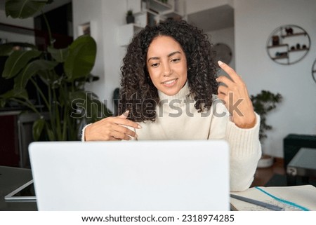 Latin professional woman remote worker hybrid working online at home having virtual conference meeting, video calling learning english class, elearning webinar on pc computer sitting at table. Royalty-Free Stock Photo #2318974285