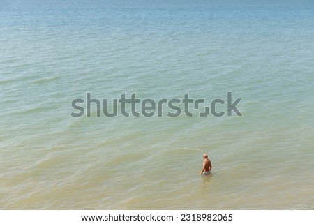 Lone mature man, topless. wading in the sea on a warm summer day seen from above Royalty-Free Stock Photo #2318982065