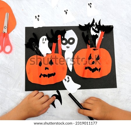 Halloween decor. Concept for Halloween. DIY. Child making pumpkins and ghost for the holiday of halloween. Funny crafts from paper. 