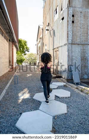 Woman in sports clothes walking outdoors at daytime.