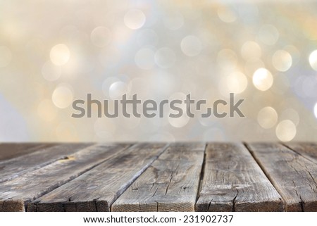 rustic wood table in front of glitter silver and gold bright bokeh lights 