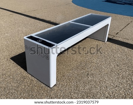 Smart bench with solar panels, WiFi, and USB or wireless charging for cellphones. Royalty-Free Stock Photo #2319037579