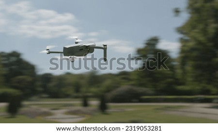 Flying drone in beautiful green garden with blur effect.