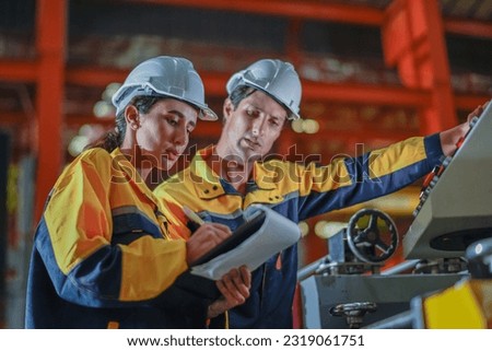 Factory apprenticeship. Man mentor teaching Female employees trainee operating machine looking monitors and check Production process machinery. foreman explaining woman engineer control machine Royalty-Free Stock Photo #2319061751