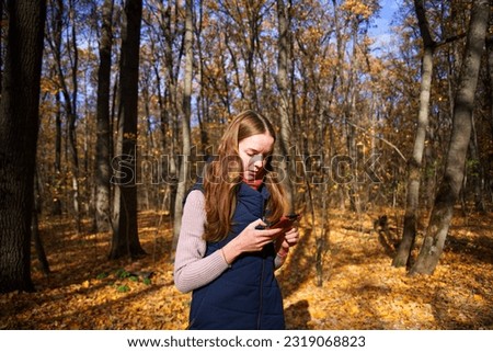 Girl taking pictures on the phone in the Kharkov forest park