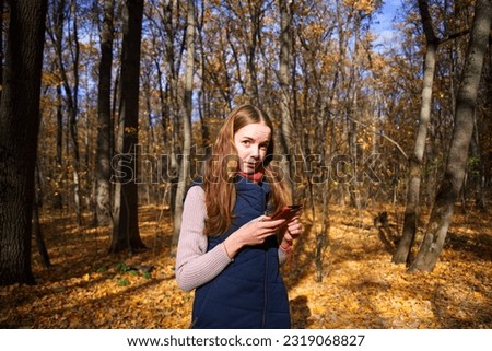Girl taking pictures on the phone in the Kharkov forest park