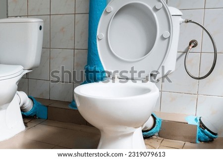 Two toilets side by side. Toilet for two. There are two toilets next to each other. Place to talk