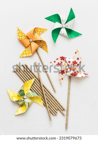 We make homemade bright paper pinwheels on a light background, top view. Creativity concept   Royalty-Free Stock Photo #2319079673