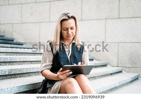 Woman businesswoman with a tablet works with financial data in the business of the city. Technology, development, growth concept