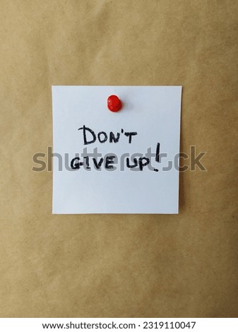 Don't give up written on a sticky note and pinned on a board Royalty-Free Stock Photo #2319110047