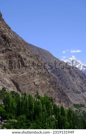 Landscape in the mountains and river, beautiful mountain lodge, lush trees on the slopes of mountains with blue sky