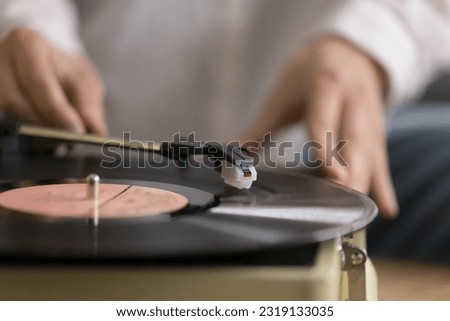 Close up view unknown female using old-fashioned equipment to listening favourite music on vinyl record old turntable player. Classical melody for retro style sound lovers, leisure, nostalgic mood Royalty-Free Stock Photo #2319133035