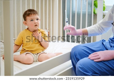 The white-coated medical professional is explaining the benefits of the vaccine to the parents before administering it to the child. Kid aged about two years (one year eleven months)