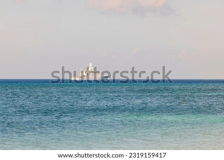 View of large white warship moving across turquoise waters of Atlantic Ocean. Aruba. Royalty-Free Stock Photo #2319159417