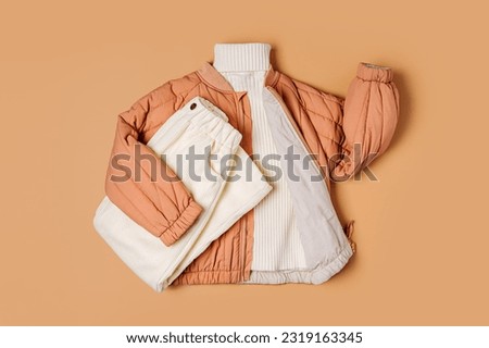 Stylish terracotta children's autumn jacket with knitted sweater and  trousers. Fashion kids outfit for for spring, autumn or winter. Flat lay, top view