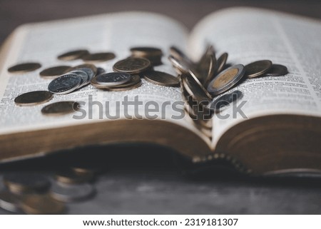 One tenth or tithe is basis on which Bible teaches us to donate one tenth of first fruit to God. Coins with Holy Bible. Religion donation and funding. Giving money, the symbol of Christianity donation