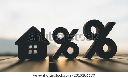 Silhouette of Percentage and house sign symbol icon wooden on wood table. Concepts of home interest, real estate, investing in inflationม home loan interest rate hike.
