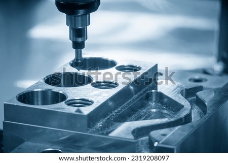 The CNC milling machine chamfer cutting mold base part by chamfer tool in the light blue scene. The mold parts cutting process by machining center with solid ball end mill. Royalty-Free Stock Photo #2319208097