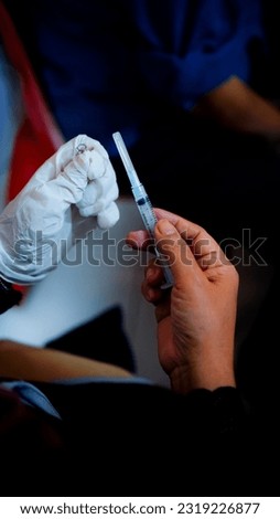 A mother's hand examining a syringe after use    