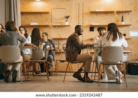 Diverse, inter-generational group of creative people working on a new project at modern co working space Royalty-Free Stock Photo #2319242487