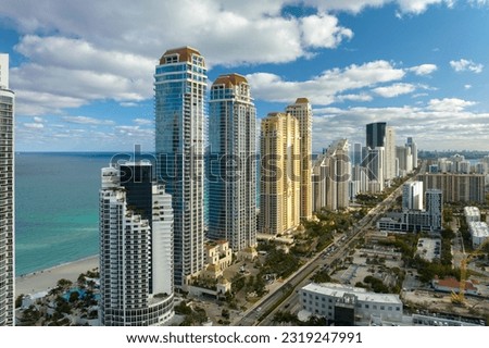 View from above of luxurious highrise hotels and condos on Atlantic ocean shore in Sunny Isles Beach city. Urban street with busy traffic. American tourism infrastructure in southern Florida