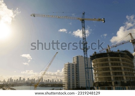 Aerial view of new developing residense in american urban area. Tower cranes at industrial construction site in Miami, Florida. Concept of housing growth in the USA Royalty-Free Stock Photo #2319248129