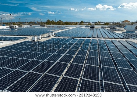 Aerial view of blue photovoltaic solar panels mounted on industrial building roof for producing clean ecological electricity. Production of renewable energy concept Royalty-Free Stock Photo #2319248153